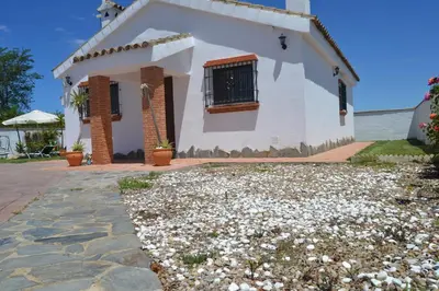 a white house with a window and a stone driveway at El Moral in Cádiz