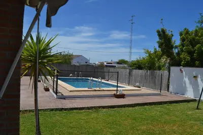 a swimming pool in a yard with a fence at El Moral in Cádiz