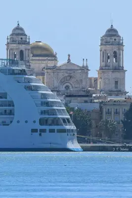 a cruise ship sitting in the water in front of a building at Apartamento Loft Puerto de Gades in Cádiz