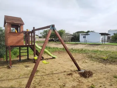 a playground with a swing set with tennis balls on it at Chiclana Mobile House - Piscina , Wi-Fi, Relax in Chiclana de la Frontera