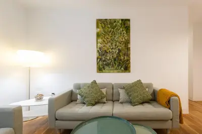 a living room with a couch and a painting on the wall at El DESCANSO de San Antonio by Cadiz4Rentals in Cádiz