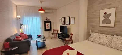 a bedroom with a bed and a living room at El rincón de la Caleta in Cádiz