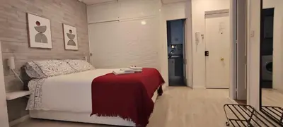 a bedroom with a bed with a red blanket on a table at El rincón de la Caleta in Cádiz