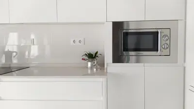 a kitchen with white cabinets and a microwave at Sherryflat Teatro in Jerez de la Frontera