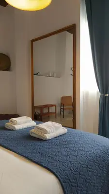 two towels on a bed in a bedroom with a mirror at Sherryflat Teatro in Jerez de la Frontera