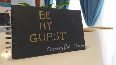 a book that says be my guest on a desk at Sherryflat Teatro in Jerez de la Frontera