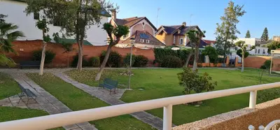 a view of a yard with chairs and trees at APTARTAMENTO DOÑANA RECIEN REFORMADO Parking gratis in Sanlúcar de Barrameda