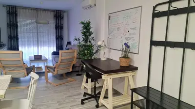 a room with a table and chairs and a white wall at APTARTAMENTO DOÑANA RECIEN REFORMADO Parking gratis in Sanlúcar de Barrameda