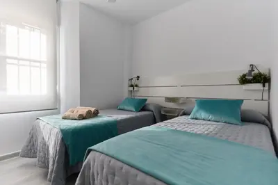 a bedroom with two beds with blue sheets at APTARTAMENTO DOÑANA RECIEN REFORMADO Parking gratis in Sanlúcar de Barrameda