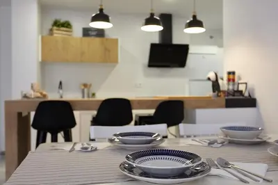 a table with plates and utensils on top of it at APTARTAMENTO DOÑANA RECIEN REFORMADO Parking gratis in Sanlúcar de Barrameda