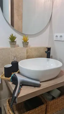a bathroom with a white sink and a mirror at APTARTAMENTO DOÑANA RECIEN REFORMADO Parking gratis in Sanlúcar de Barrameda