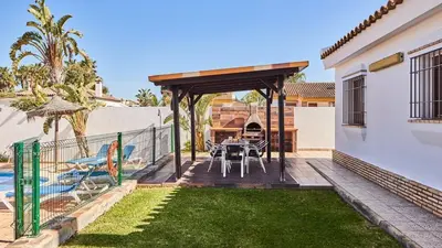 a patio with a table and chairs in a yard at Chalet El Cancelín Conil de la Frontera by Ruralidays in Conil de la Frontera