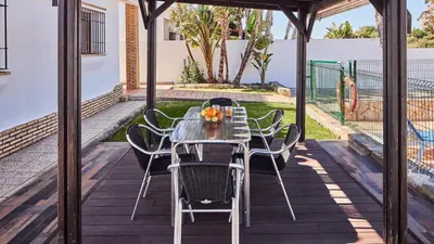 a patio with a table and chairs on a deck at Chalet El Cancelín Conil de la Frontera by Ruralidays in Conil de la Frontera