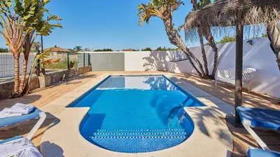 a swimming pool with blue water in a yard at Chalet La Raya Conil de la Frontera by Ruralidays in Conil de la Frontera
