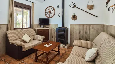 a living room with two couches and a wood stove at Chalet La Raya Conil de la Frontera by Ruralidays in Conil de la Frontera