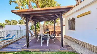 a wooden deck with a table and chairs at Chalet La Raya Conil de la Frontera by Ruralidays in Conil de la Frontera