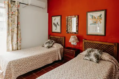 two beds in a room with red walls at Dehesa de las Yeguas casa en finca privada con piscina y playa in Cádiz