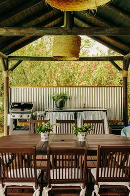 a wooden table with chairs and a grill on a patio at Dehesa de las Yeguas casa en finca privada con piscina y playa in Cádiz