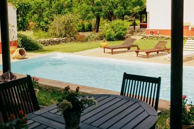 a table and chairs next to a swimming pool at Dehesa de las Yeguas casa en finca privada con piscina y playa in Cádiz