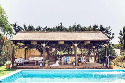 a gazebo next to a swimming pool at Dehesa de las Yeguas casa en finca privada con piscina y playa in Cádiz