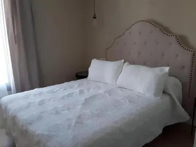 a white bed with white sheets and pillows at Casa La Palmera - Sólo Familias y Parejas in Conil de la Frontera
