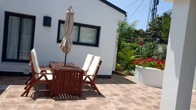 a patio with a table and chairs and an umbrella at Casa La Palmera - Sólo Familias y Parejas in Conil de la Frontera