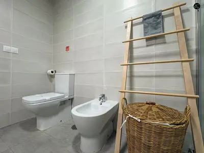 a white bedroom with a bed and two windows at ARTE Playa la Caleta Grupo AC Gestion in Cádiz