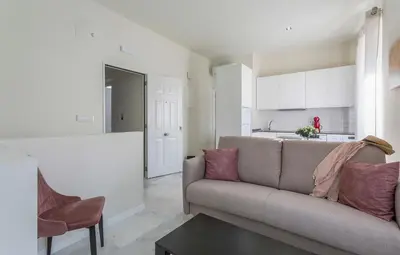 a living room with a couch and a kitchen at LalaSuites CORREDERA in Jerez de la Frontera