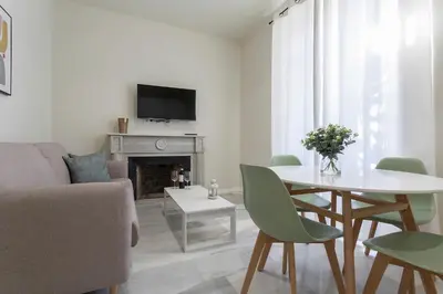 a white living room with a table and a couch at LalaSuites CORREDERA in Jerez de la Frontera