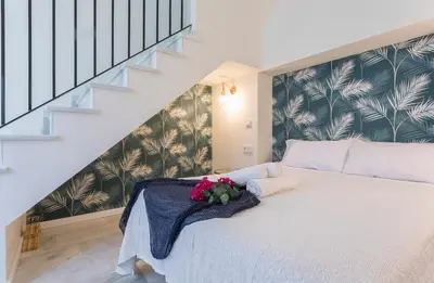 a bedroom with a white bed with flowers on it at LalaSuites CORREDERA in Jerez de la Frontera