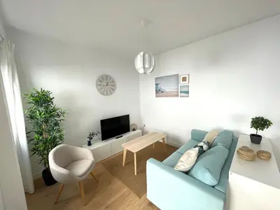 a living room with a blue couch and a tv at No 10 Cádiz in Cádiz