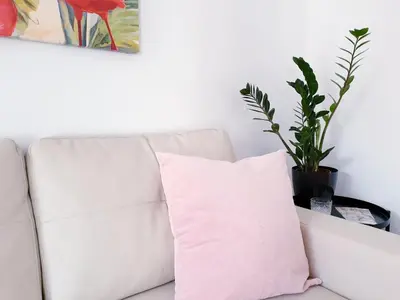 a white couch with a pink pillow on it at Sherryflat C/Larga in Jerez de la Frontera
