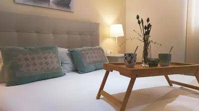 a bedroom with a bed with a table and pillows at Sherryflat C/Larga in Jerez de la Frontera
