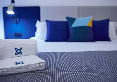 a hotel room with a bed with towels on it at ISA Cádiz Palacio de Congresos in Cádiz