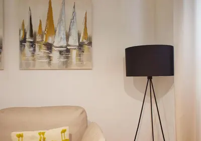 a lamp in a living room next to a chair at ISA Cádiz Palacio de Congresos in Cádiz
