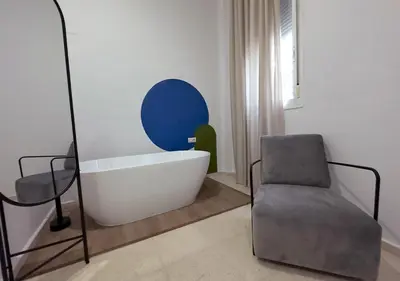 a bath tub and a chair in a bathroom at ISA Cádiz Palacio de Congresos in Cádiz