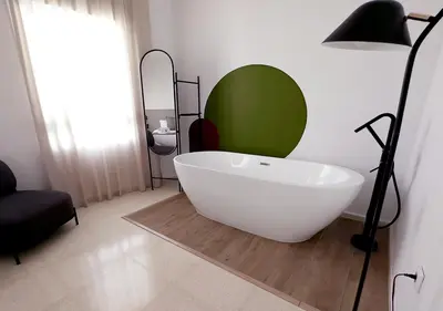 a white bath tub in a room with a lamp at ISA Cádiz Palacio de Congresos in Cádiz