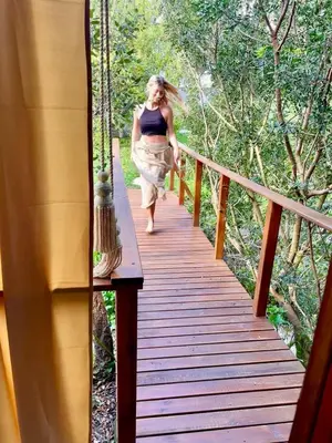 a woman walking down a wooden walkway at Glamping - La Casa del Piano in Chiclana de la Frontera