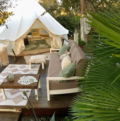 a patio with a couch and a tent at Glamping - La Casa del Piano in Chiclana de la Frontera