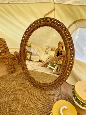 a woman sitting in a chair in front of a mirror at Glamping - La Casa del Piano in Chiclana de la Frontera