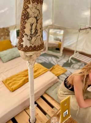 a woman sitting on the floor next to a table with a dress at Glamping - La Casa del Piano in Chiclana de la Frontera