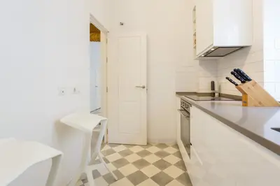 a white kitchen with a checkered floor at The QUEEN's Designer Apartment by Cadiz4Rentals in Cádiz