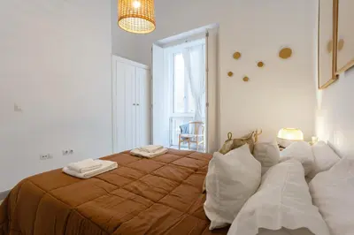a bedroom with a large bed with white pillows at The QUEEN's Designer Apartment by Cadiz4Rentals in Cádiz