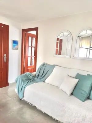 a white couch with a blanket on top of it at JMC Apartamento CENTRO HISTÓRICO in El Puerto de Santa María