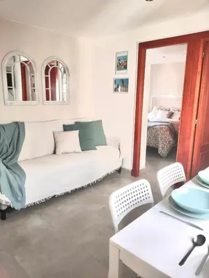 a living room with a white couch and a bed at JMC Apartamento CENTRO HISTÓRICO in El Puerto de Santa María