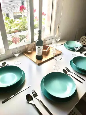 a table with green plates and a bottle of wine at JMC Apartamento CENTRO HISTÓRICO in El Puerto de Santa María