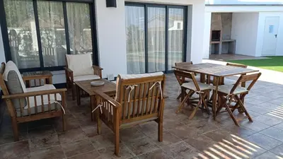 a patio with a wooden table and chairs at Falsa Pimienta - Sólo Familias y Parejas in Conil de la Frontera