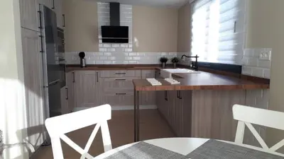a kitchen with a sink and a counter with two white chairs at Falsa Pimienta - Sólo Familias y Parejas in Conil de la Frontera