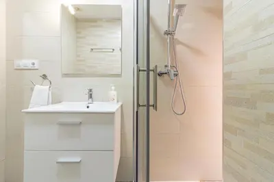 a bathroom with a toilet and a sink and a shower at Allo Apartments Plateros Centro Jacuzzi Comunitario in Jerez de la Frontera