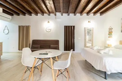 a bedroom with a bed and a table and chairs at Allo Apartments Plateros Centro Jacuzzi Comunitario in Jerez de la Frontera